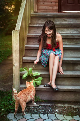 girl-on-front-steps-of-home-for-sale-playing-with-cat-Reazo-real-estate
