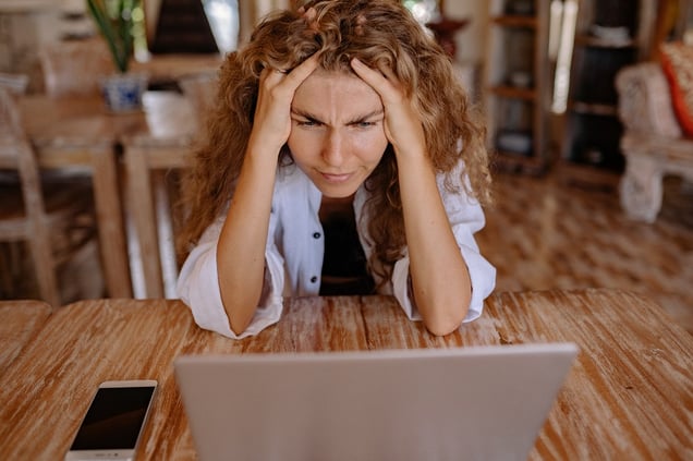 woman-staring-at-laptop-shocked-over-negative-real-estate-review-Reazo-real-estate-leads