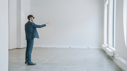 man-wearing-virtual-reality-glasses-envisioning-furniture-in-empty-house-remodeling-Reazo-real-estate