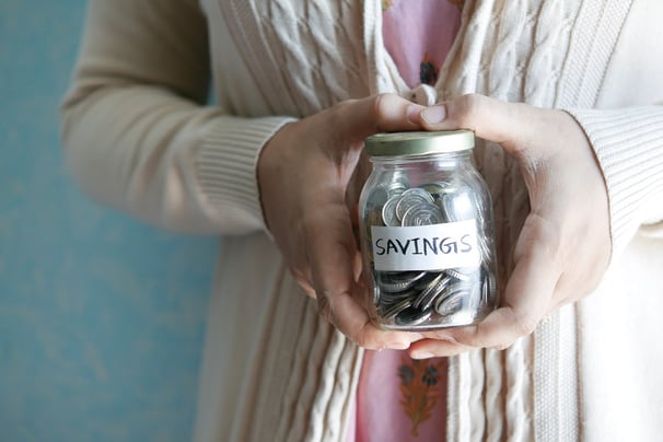 woman-holding-jar-of-coins-savings-down-payment-assistance-Reazo-real-estate