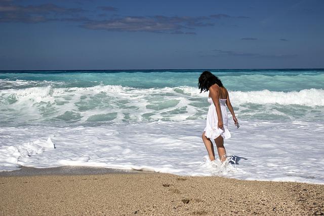 woman-in-dress-walking-in-ocean-waves-heatwave-tactics-Reazo-real-estate