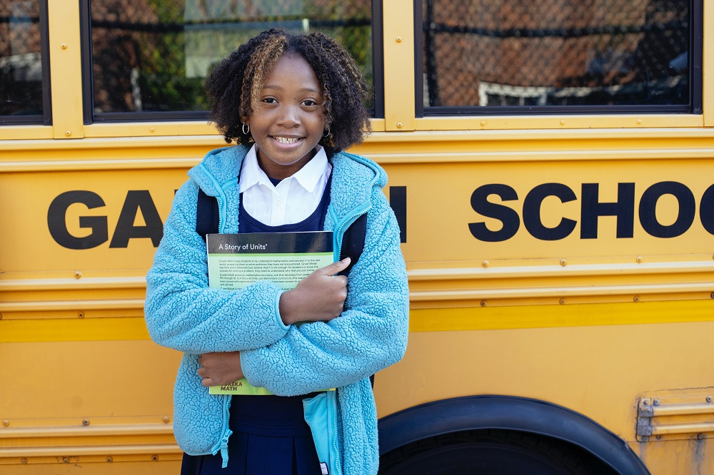 child-standing-by-school-bus-unbiased-good-school-districts-Reazo-real-estate