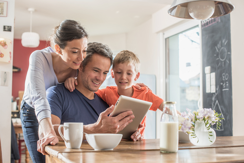 family-in-new-house-looking-at-tablet-Reazo-real-estate